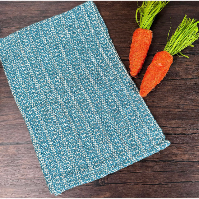 Dark Teal and white honeycomb design dish towels hand woven hemp and cotton blend. Pictured on a brown table with two carrots.