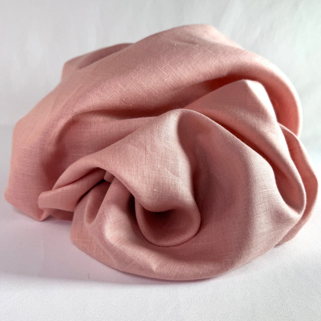 Pink fabric scrunched pile on a white background