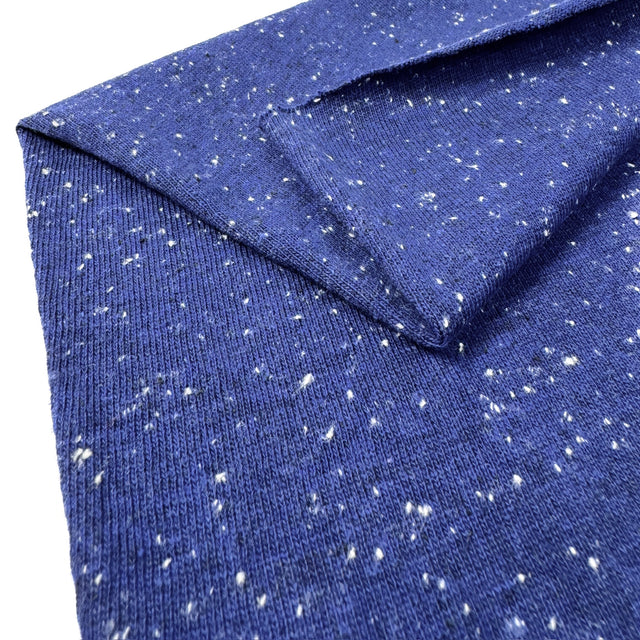Blue jersey with white speckles, folded on a white background
