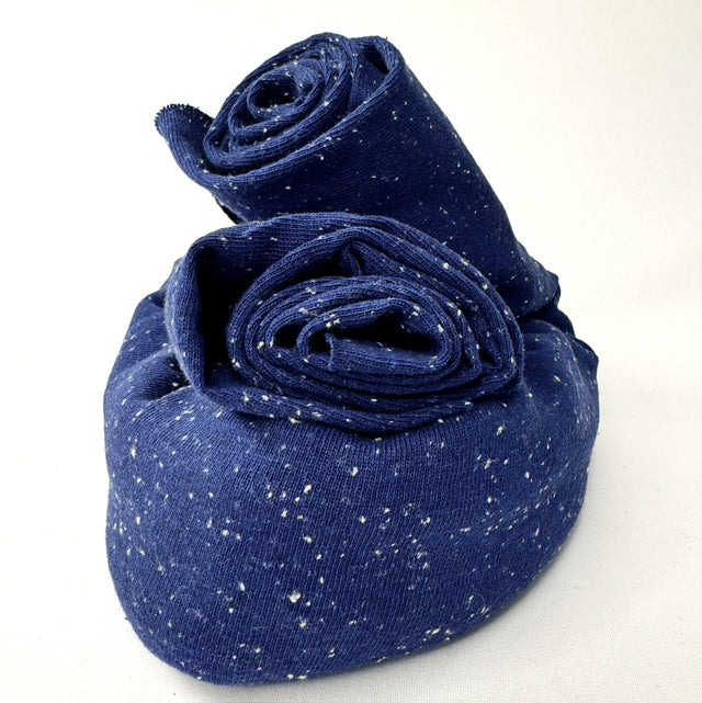 Rolled-up blue jersey with white speckles on a white background