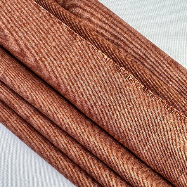 Terra Cotta hemp twill layered on an angle on a white background