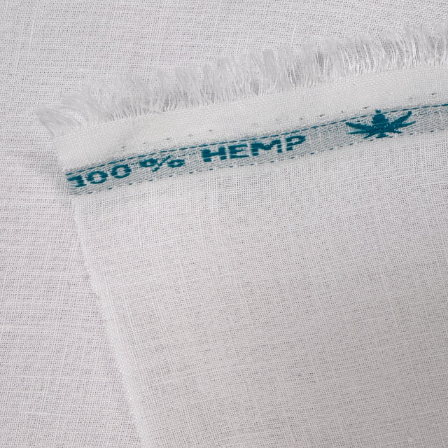 Close-up of white fabric with a '100% Hemp' label.