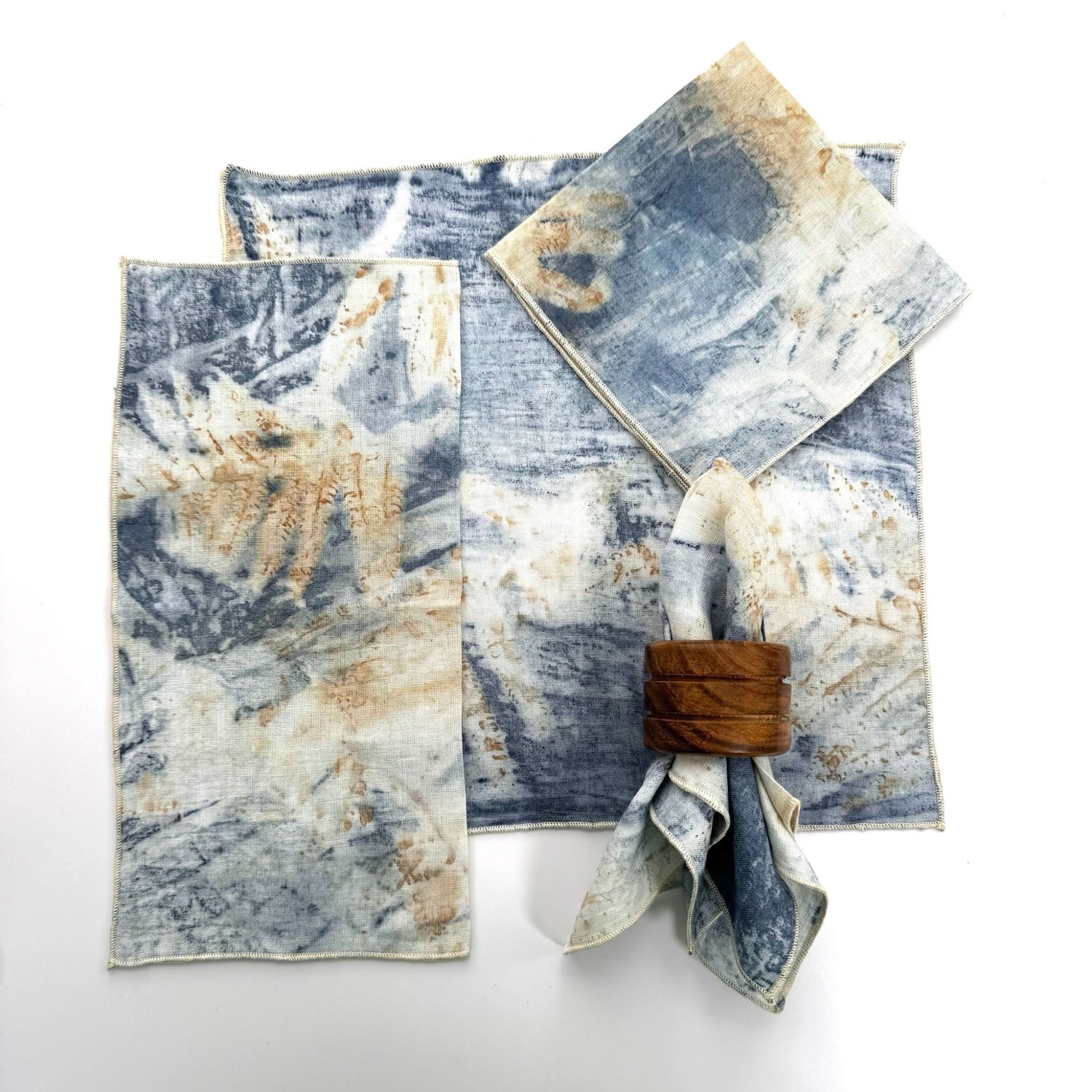 100% hemp blue eco print color table napkin pictured with 5 different ways to fold the napkin.  Napkins have black threading on the edge.