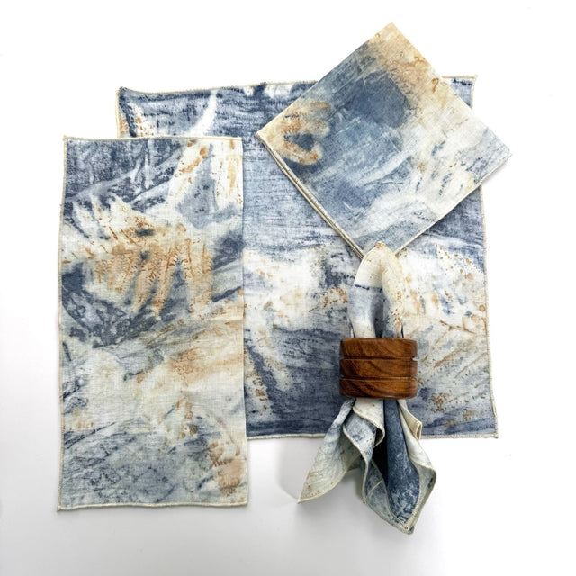 100% hemp blue eco print color table napkin pictured with 5 different ways to fold the napkin. Napkins have black threading on the edge.