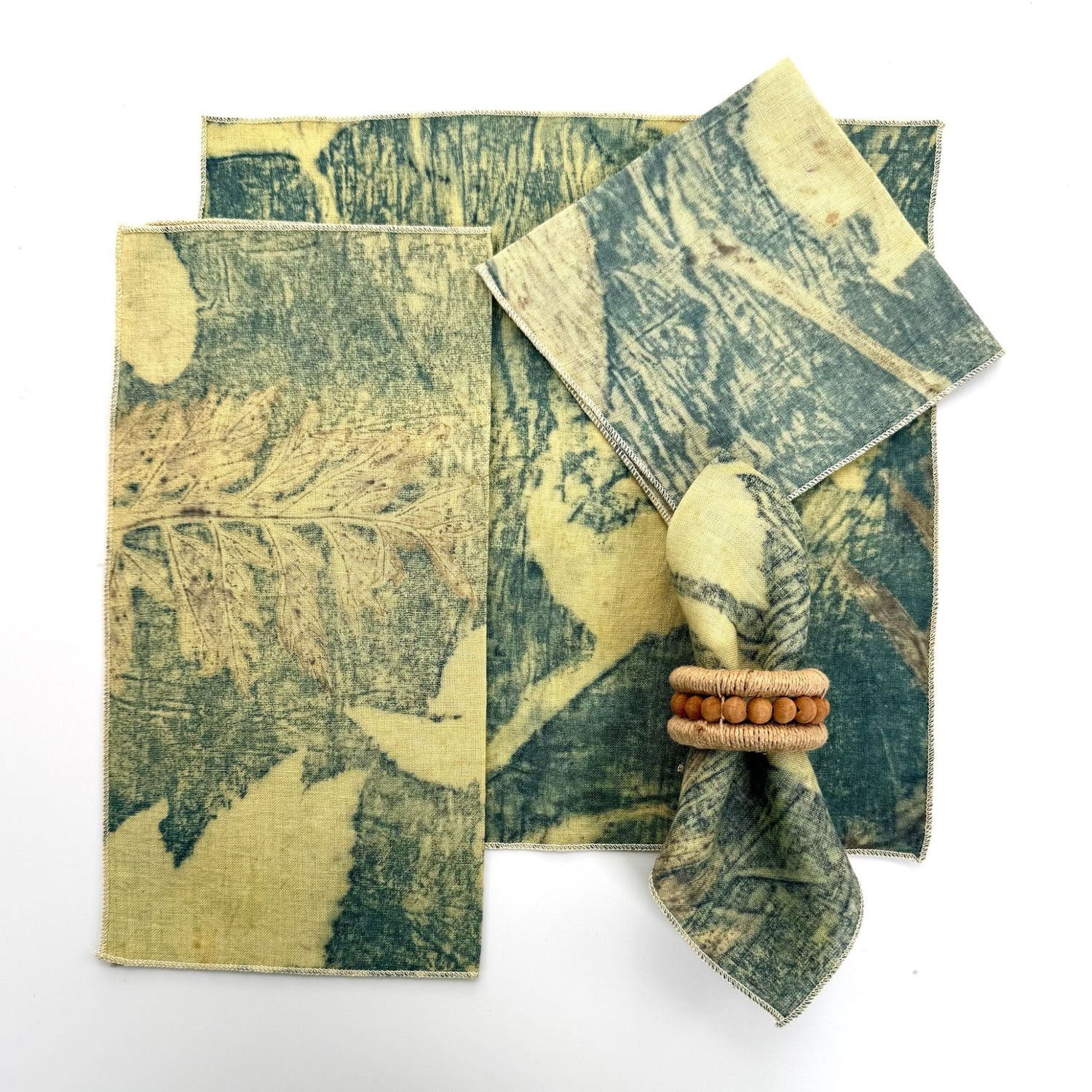 100% hemp red eco print color table napkin pictured with 5 different ways to fold the napkin.  Napkins have black threading on the edge.