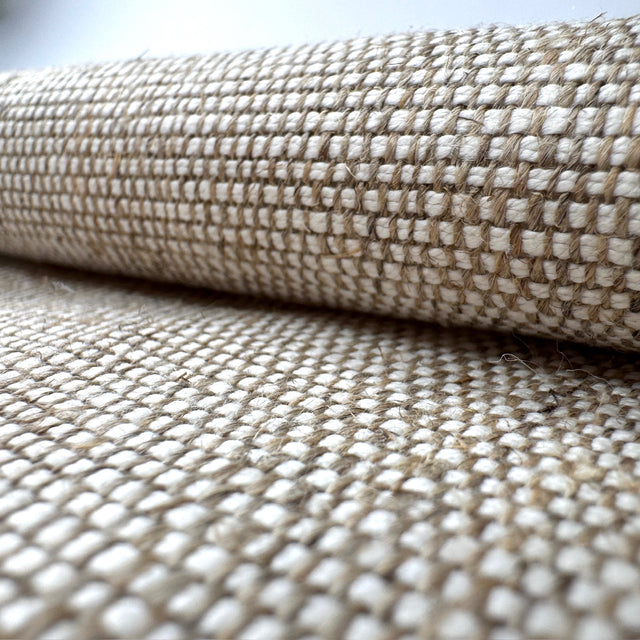 Close-up of woven fabric with a grid pattern in beige and white.