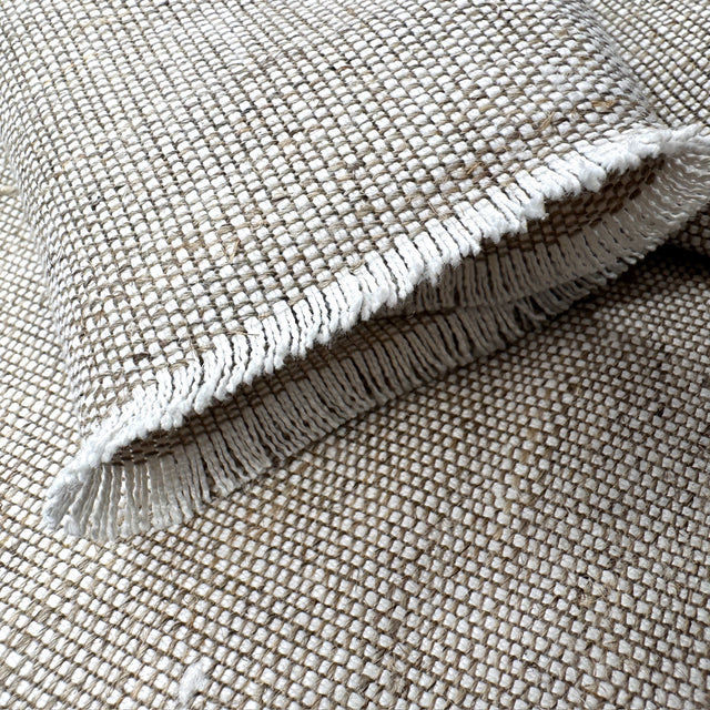 Textured fabric with frayed edge on a matching fabric background
