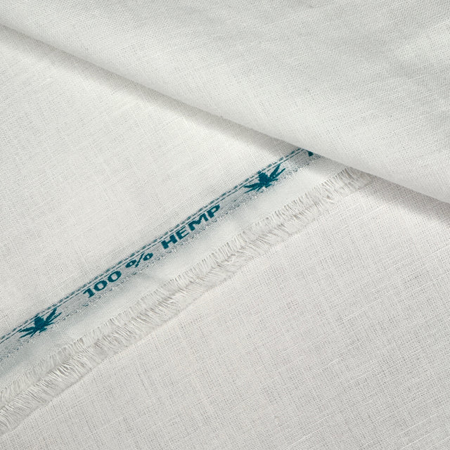 White fabric with '100% Hemp' text with frayed edge