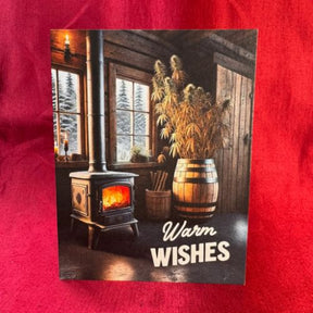 greeting card with the words warm wish and the image of a wood stove and hemp plan, on a red background