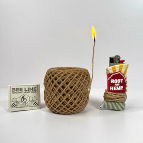 a matchbook of hemp wick, a roll of hemp lit with fire, and a toker poker wrapped in hemp wick
