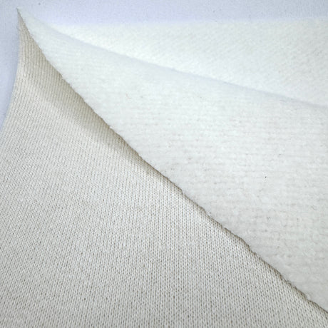 Close-up of textured cream fleece fabric on both sides with a white background