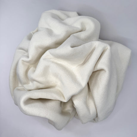 Scrunched ball of  cream fleece fabric on a light gray background