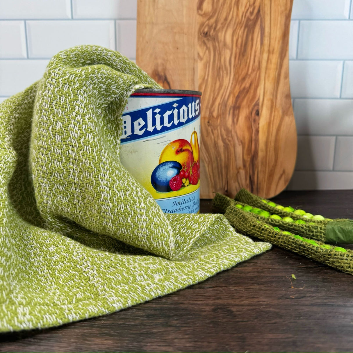 Lime Green and white honeycomb design dish towels- hand woven hemp and cotton blend.  Pictured on a brown table, draped over an antique can, with a wooden cutting board in the background and snap peas on the side.