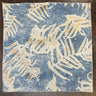 Unfolded view of the blue eco print hemp bandana, pictured on a dark wooden table.