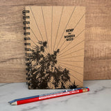 hemp paper wonderweed sketchbook with natural cover.  Print on cover is hemp plant, sun rays and words "hemp the wonderweed" in all black font. one red and one blue pencil.