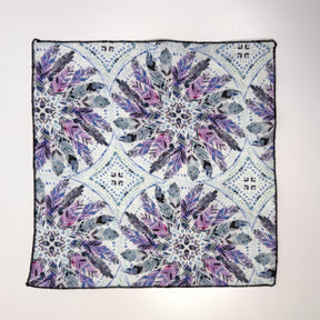 textile with geometric feather pattern featuring purple and blue colors on a white gray background.