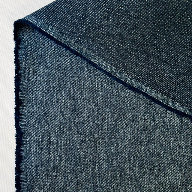 Close-up of blue denim fabric with a white background