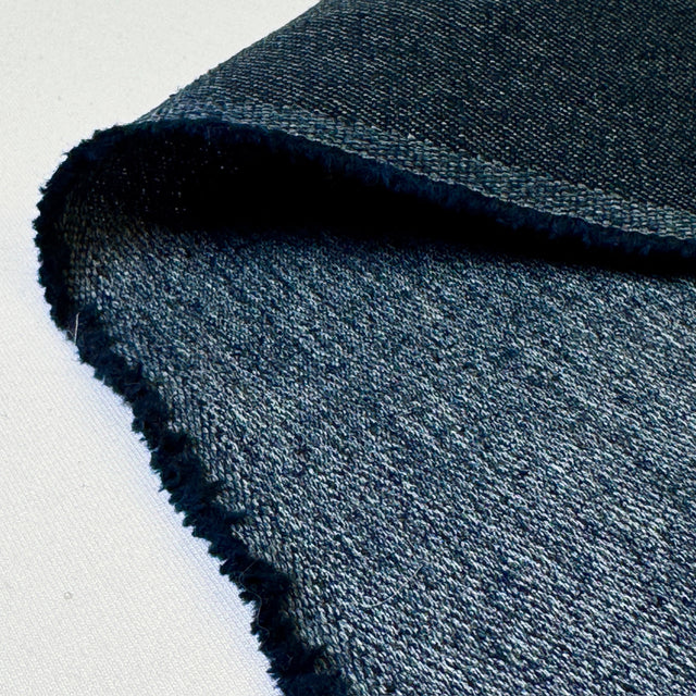 Close-up of blue denim fabric on a white background
