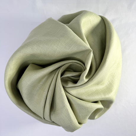 Folded light green fabric on a white background