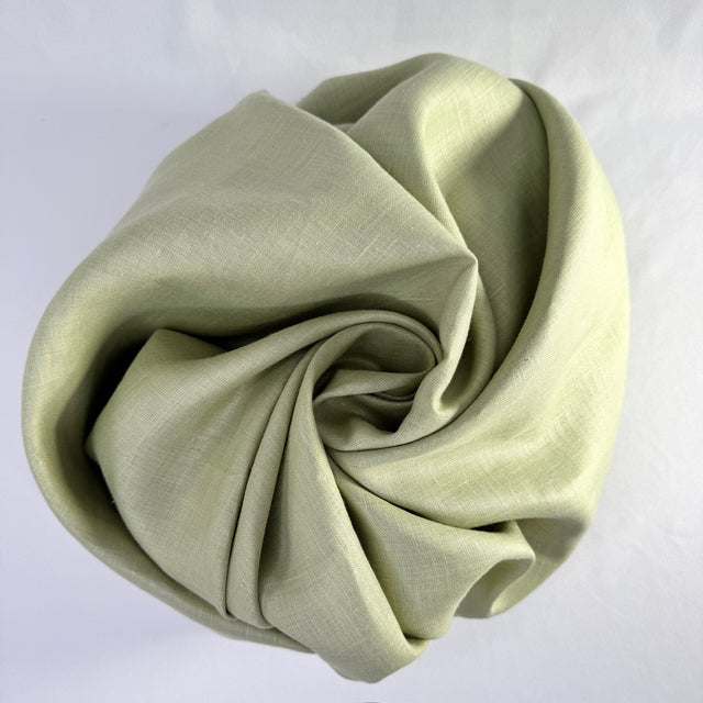 Folded light green fabric on a white background
