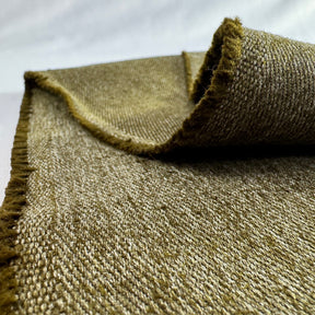 Close-up of a textured olive hemp twill fabric with frayed edges on a white background