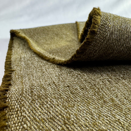 Close-up of a textured olive hemp twill fabric with frayed edges on a white background