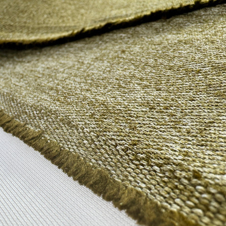 Close-up of a textured olive green hemp twill fabric with frayed edge on a white background