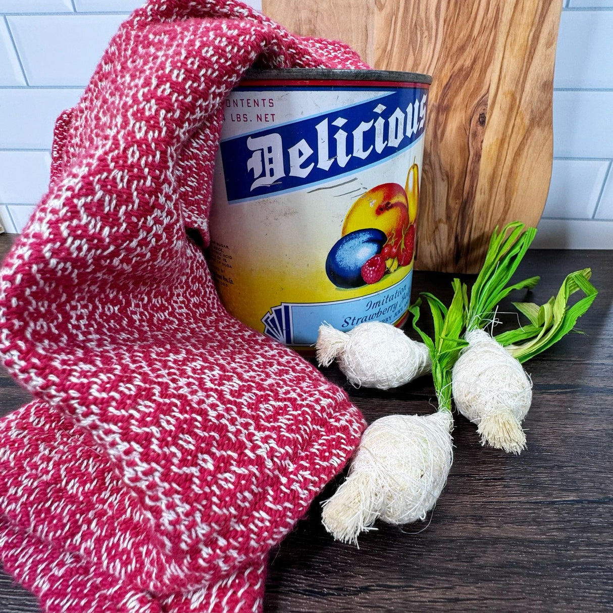 Red and white honeycomb design dish towels- hand woven hemp and cotton blend.  Pictured on a brown table, draped over an antique can, with a wooden cutting board in the background and green onions on the side.