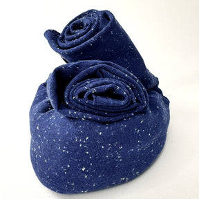 Rolled-up blue jersey with white speckles on a white background