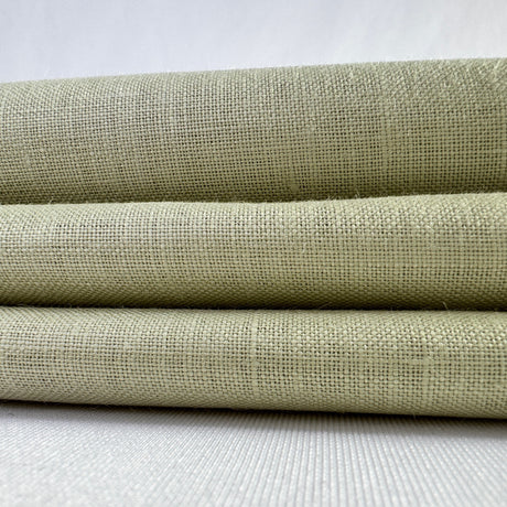 Three rolls of green fabric stacked on a white surface