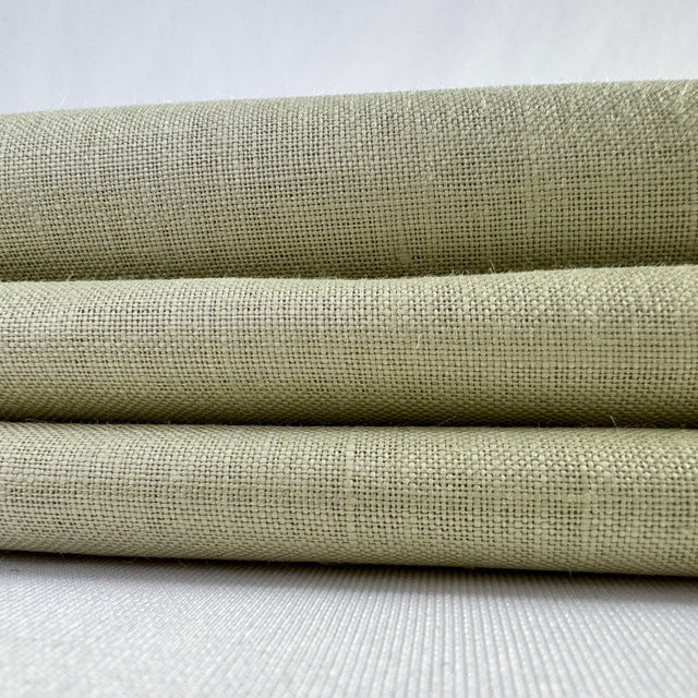 Three rolls of green fabric stacked on a white surface