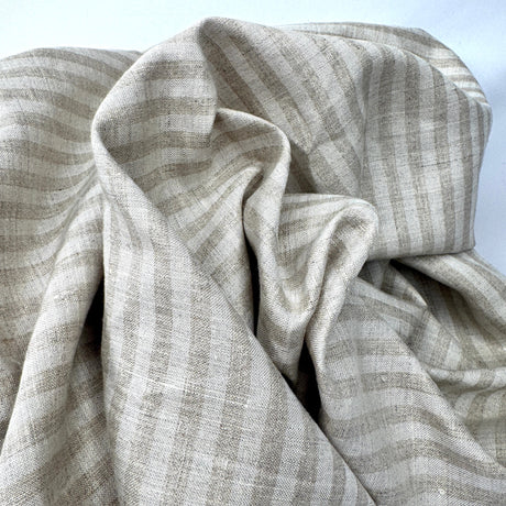 Close-up of stripe beige fabric with a subtle pattern on a light background
