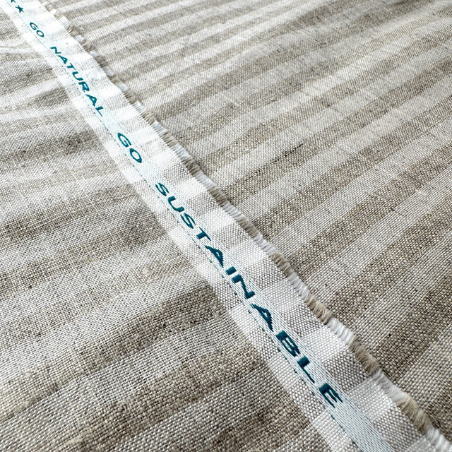 Textile with 'Go Sustainable' label on a striped fabric background