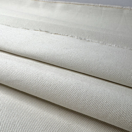 Close-up of cream fabric with a subtle pattern and edges shown