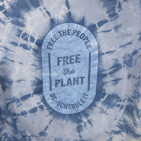 Closeup view of the printing on the back of the hoodies - "Free the People, Free the Plant, DE-Schedule it" surrounded in indigo tie-dye design.