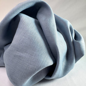 Folded light blue fabric on a neutral background