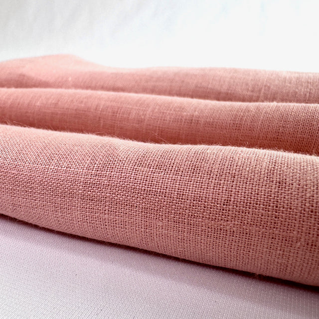Pink fabric roll on a white background