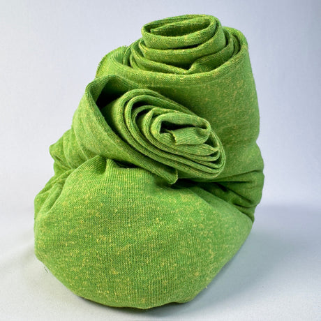 Rolled-up green fabric on a light gray background