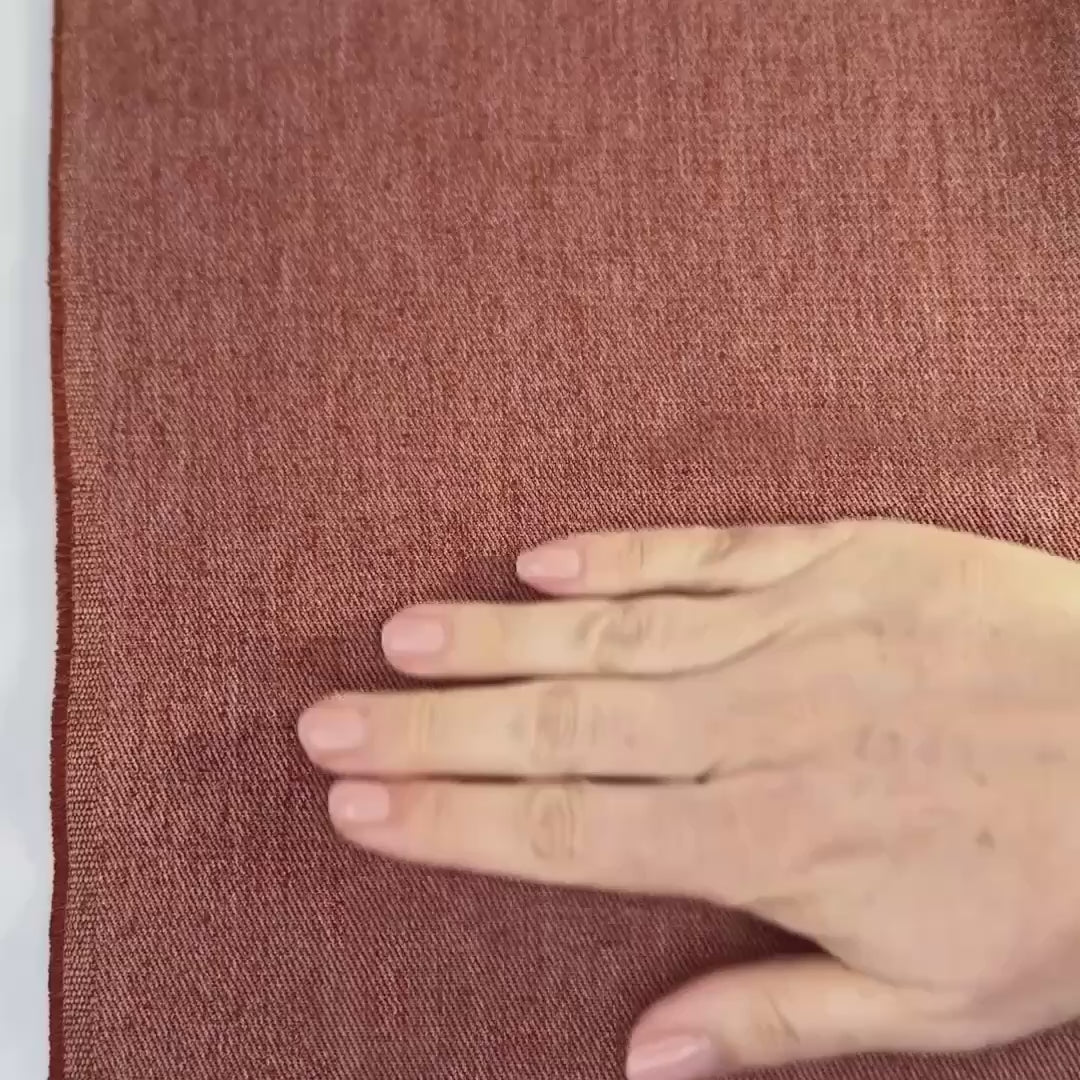 terra cotta hemp twill fabric shown with hands and scrunched