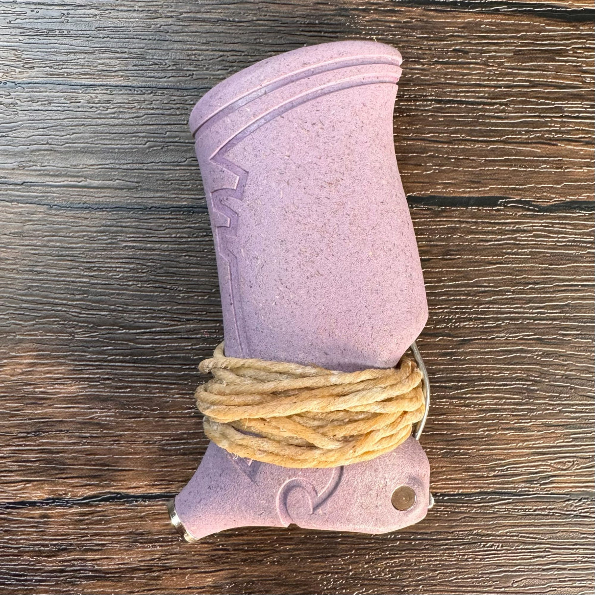 Plum colored toker poker with hemp wick wrapped around the bottom of it.  Pictured on a dark wooden surface.  