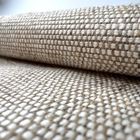 Close-up of woven fabric with a grid pattern in beige and white.
