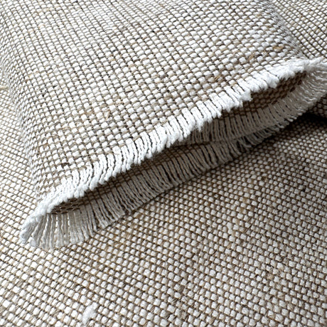 Textured fabric with frayed edge on a matching fabric background